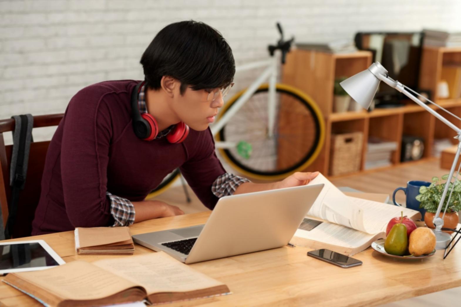 Studenten werken samen aan game development code op laptops in moderne classroom setting